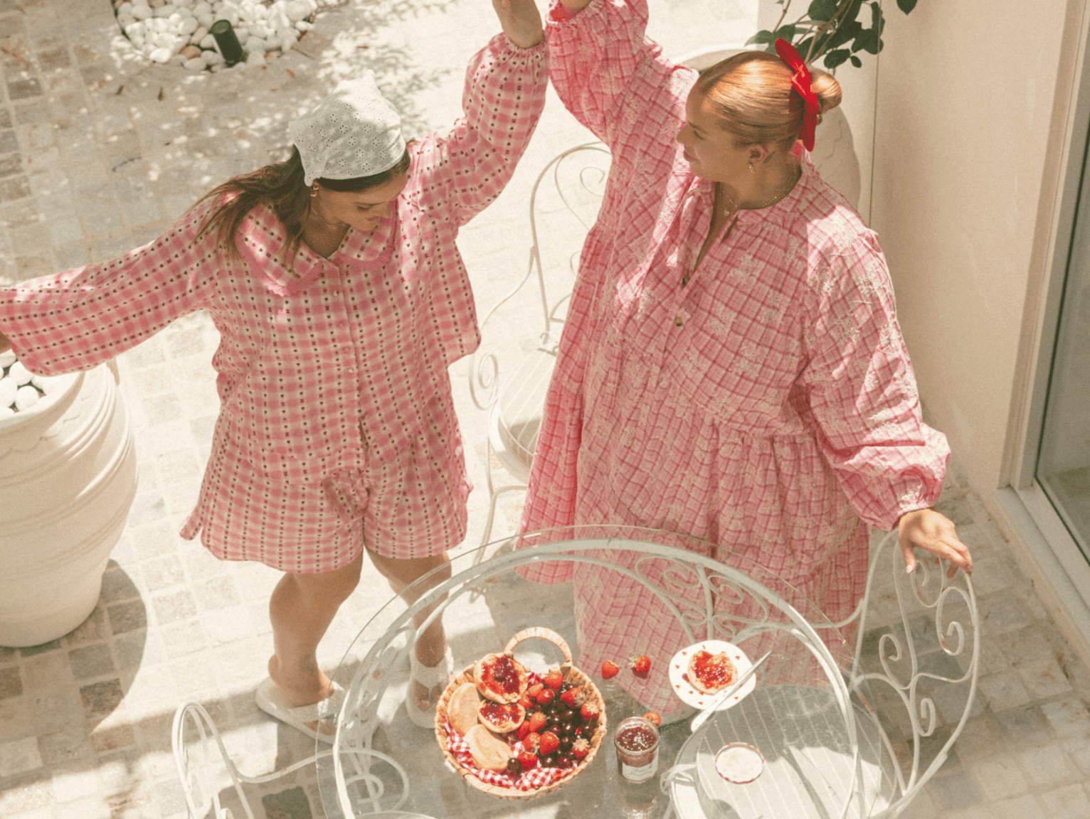 Three women wearing linen printed sets, relaxed sitting on stairs outside in a fashionable manner