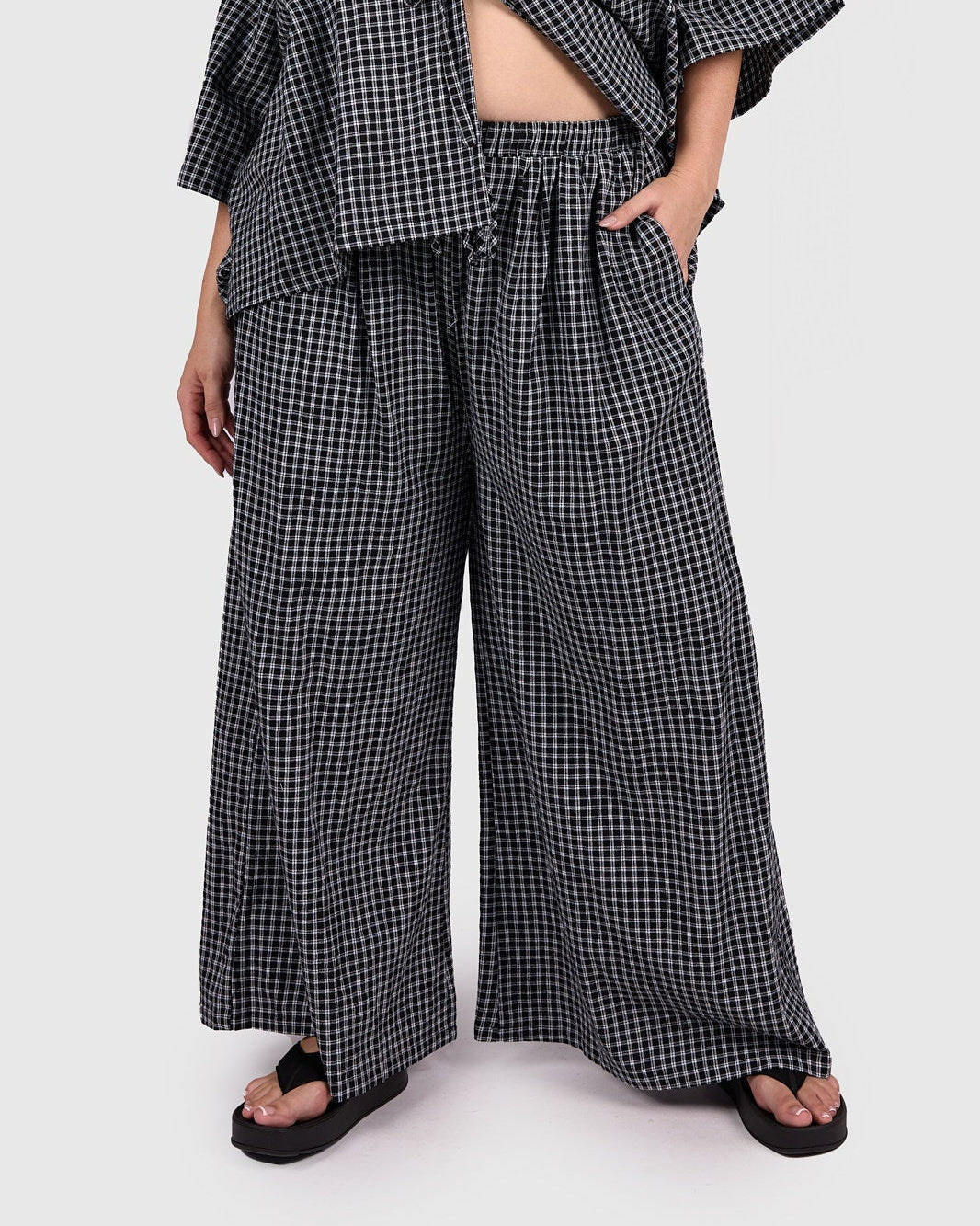 Woman wearing a black and white checkered outfit on a white background