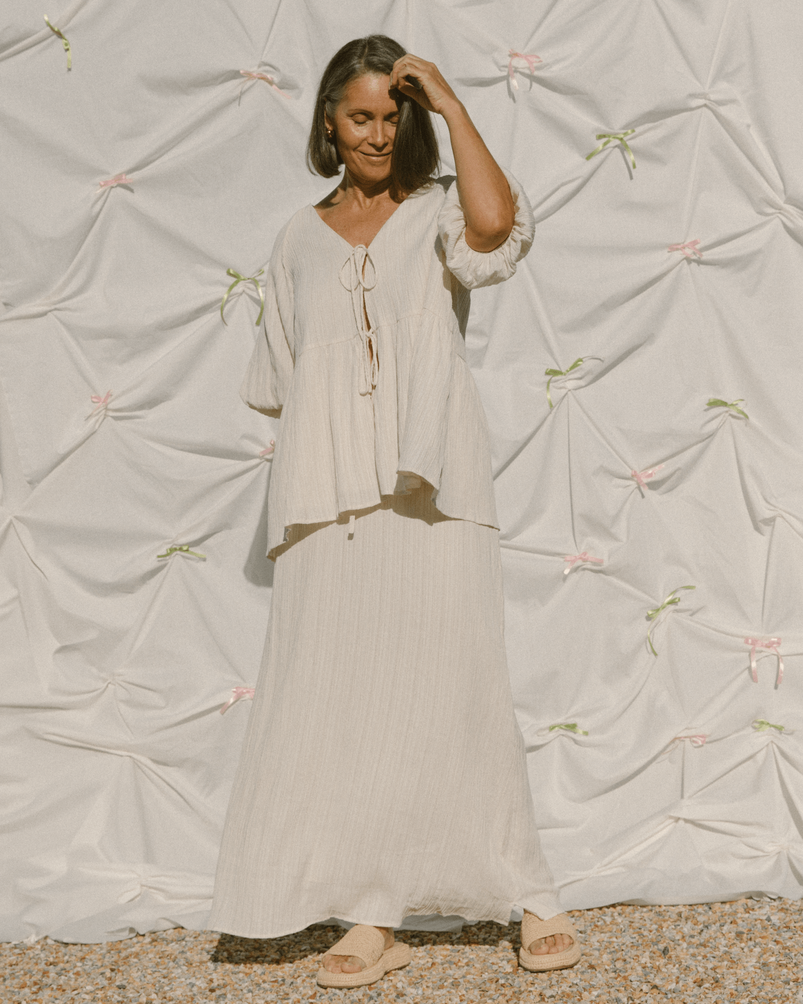 Woman wearing a flowy and breathable summer set with a tie-up blouse and whispy maxi length skirt.