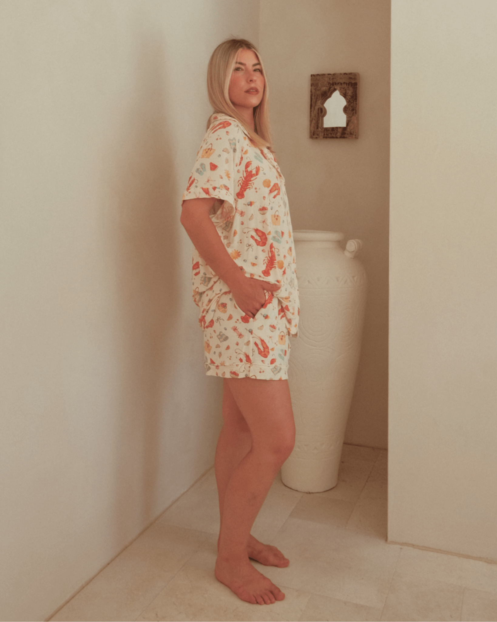 Woman wearing a warm summer printed PJ shirt & shorts co-ord set.