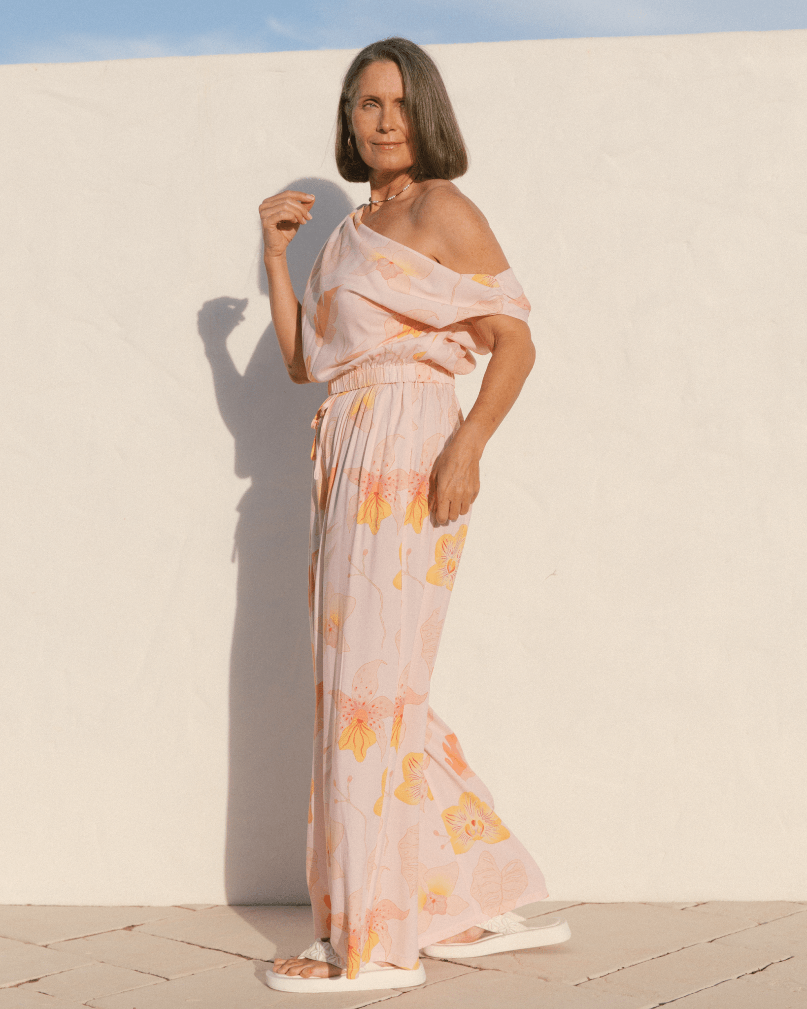 Woman wearing a spring co-ord set with an off the shoulder crop top and high-waisted flowy pants.