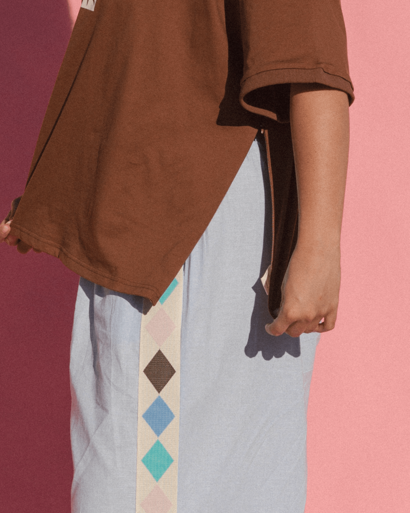 Close-up of the side-seam breastfeeding zipper on brown oversized maternity friendly tshirt.