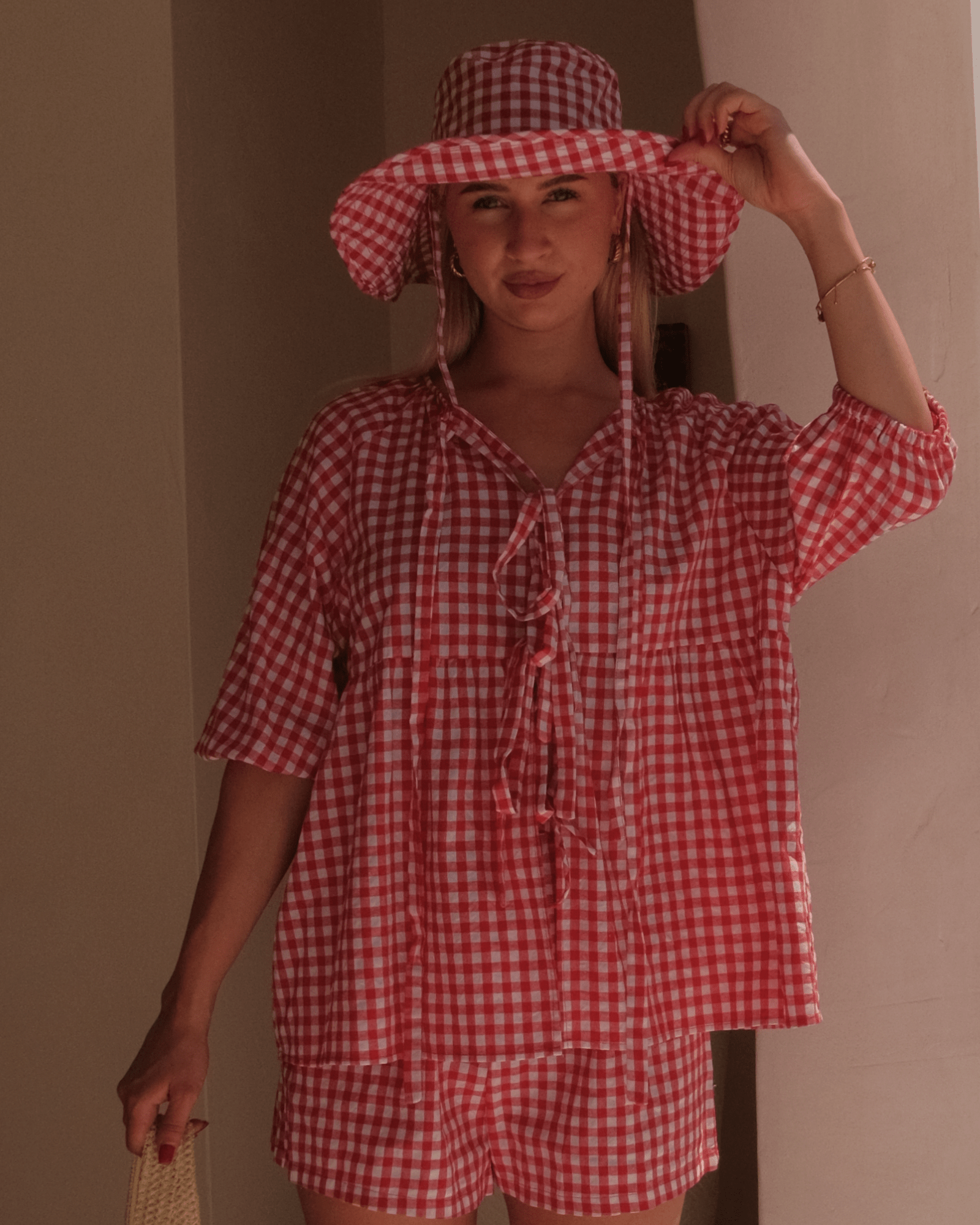 Woman wearing a stylish spring wide-brimmed gingham hat.