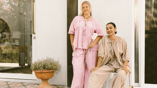 Three women wearing linen printed sets, relaxed sitting on stairs outside in a fashionable manner