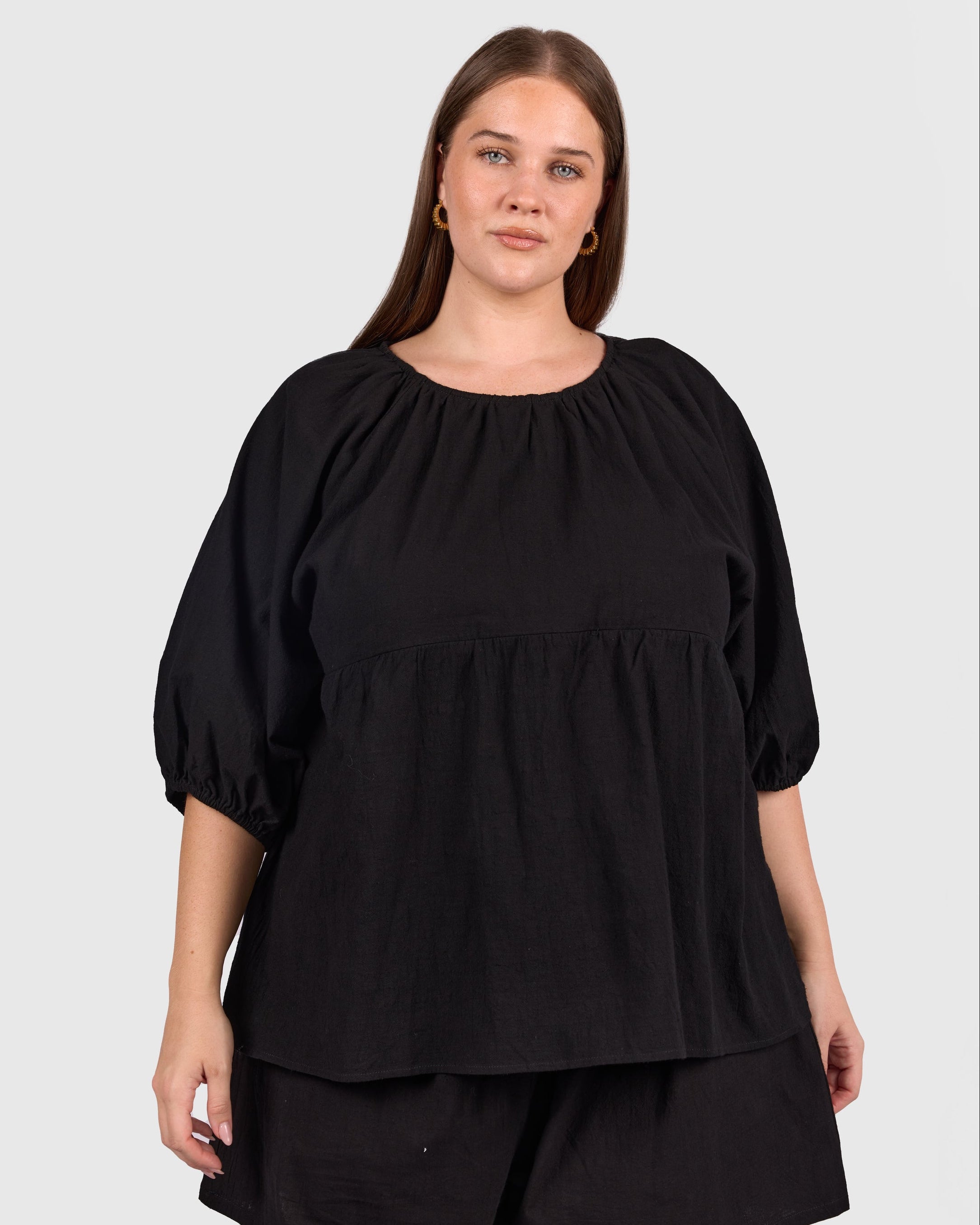 Woman wearing matching black cotton set, that is breastfeeding and bump friendly. 