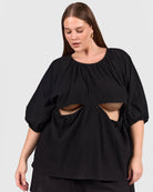Woman wearing black reversible top with breastfeeding access. 
