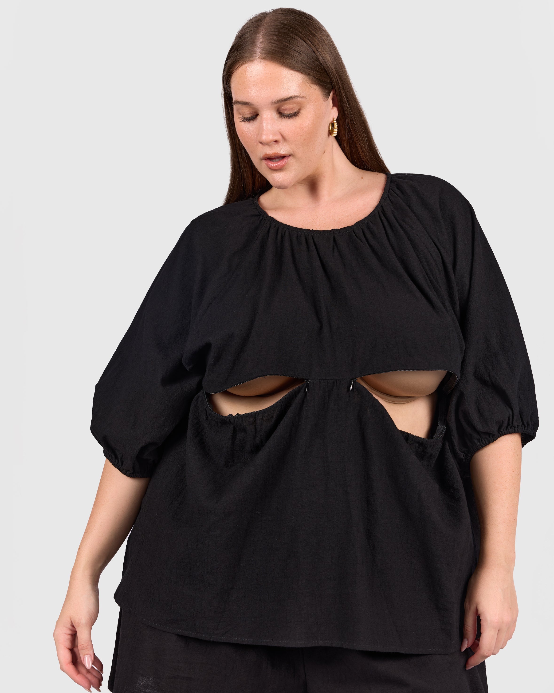 Woman wearing black reversible top with breastfeeding access. 