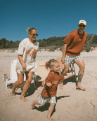 Family of three on a beach with clear blue sky