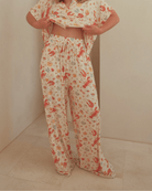 Woman wearing comfy matching loungewear in a Australian Christmas themed pattern. 