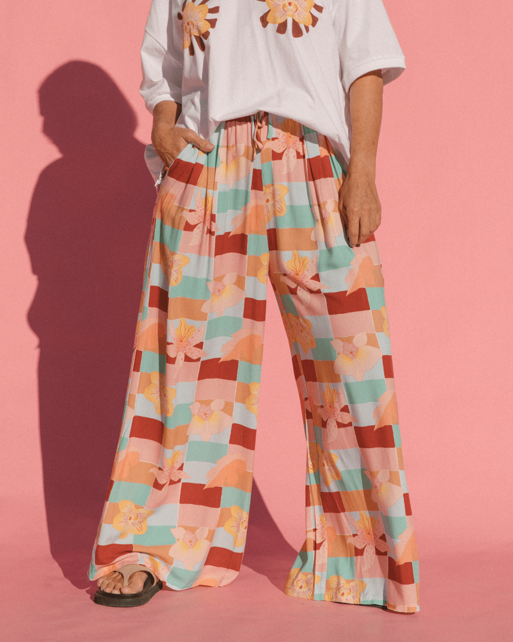 Woman wearing flowy wide legged maternity pants with elastic adjustable waistband. 